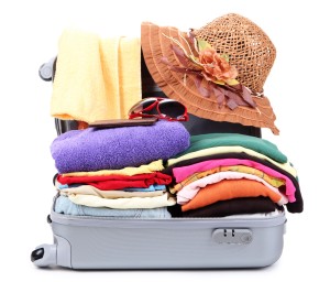 The top ten best travel tips for cruise vacations.Open silver suitcase with clothing isolated on white