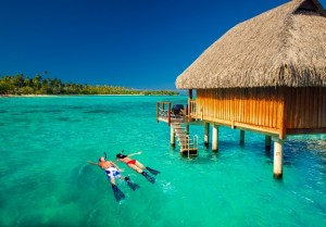 Young couple snorkling from hut over tropical lagoon