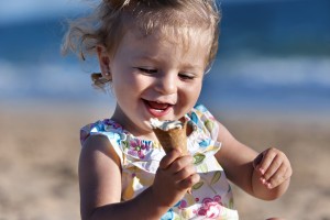 Small girl taking an ice cream in the beach